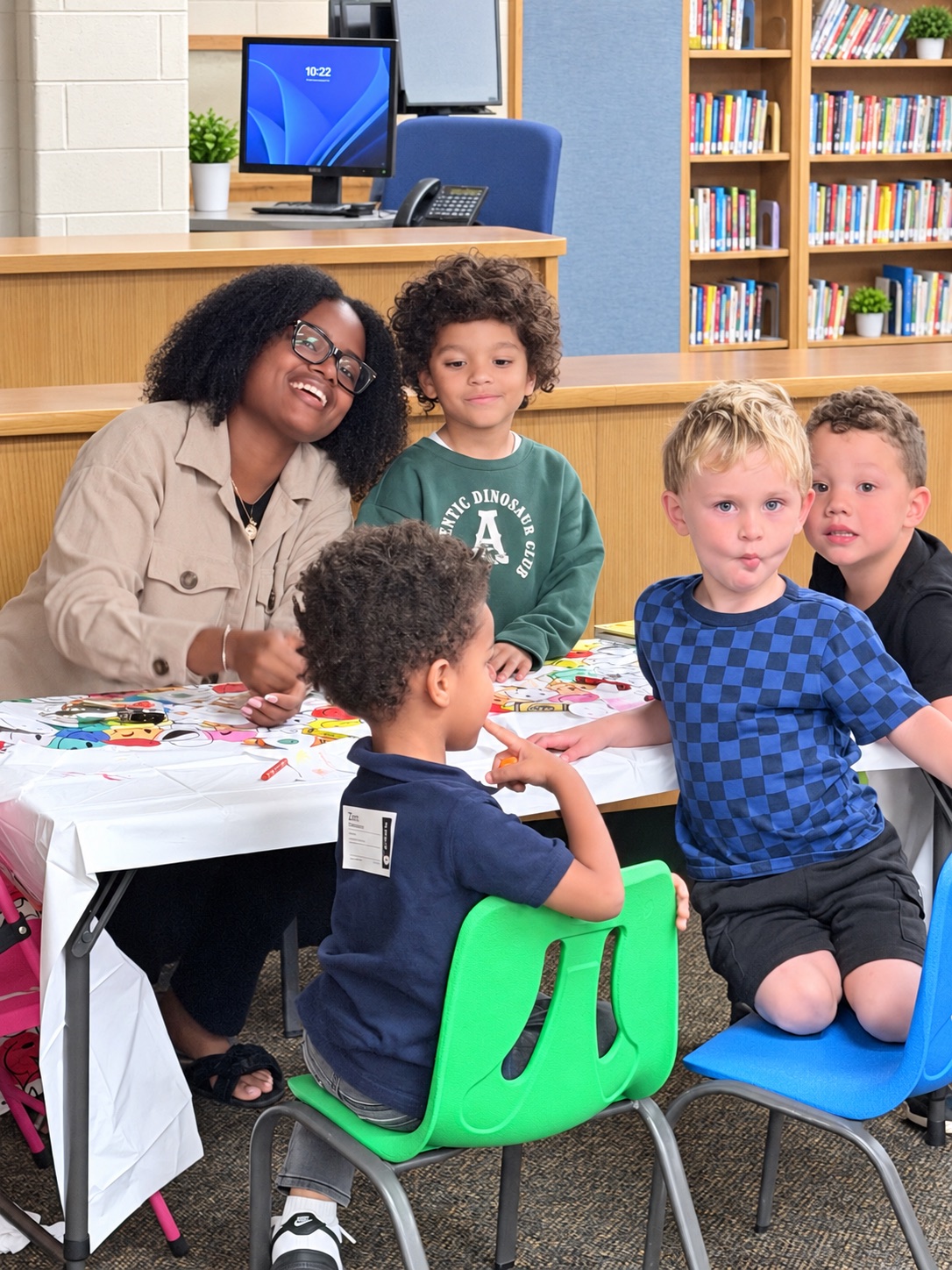 A CRWC Kidz volunteer with children at an activity table