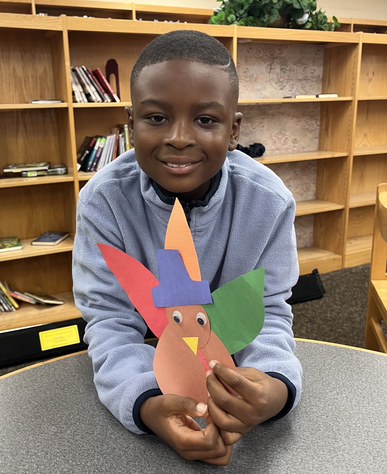 A CRWC Kidz child showing his handmade turkey craft