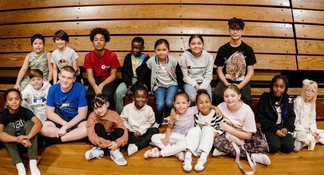 CRWC Kidz children gathered together on the gym bleachers